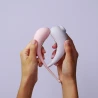 Maloo Maga - Aspirateur clitoris Lilas à droite & Oeuf vibrant connecté rose pastel a gauche tenus dans les mains