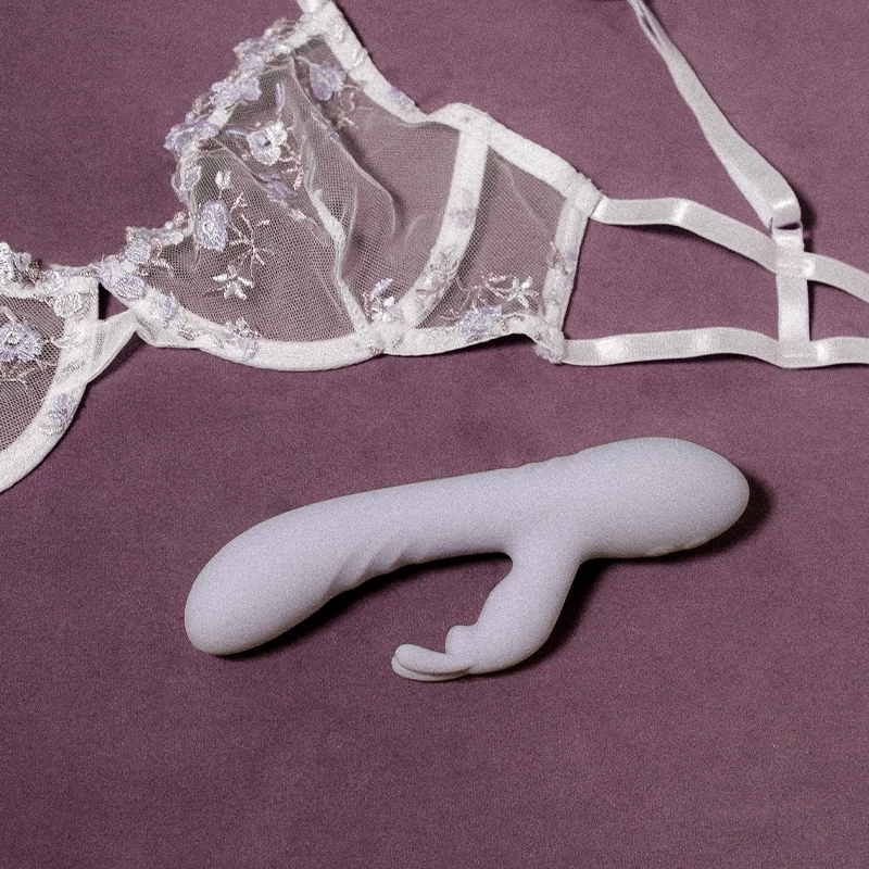 Mise en scène du sexe toys rabbit Pono sur fond violet avec un soutien gorge